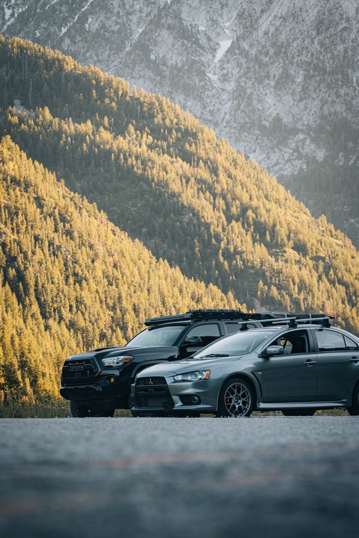 Crafting Captivating Headlines: Your awesome post title goes here Two cars parked in a sunlit mountain setting, highlighting adventure and outdoor travel.