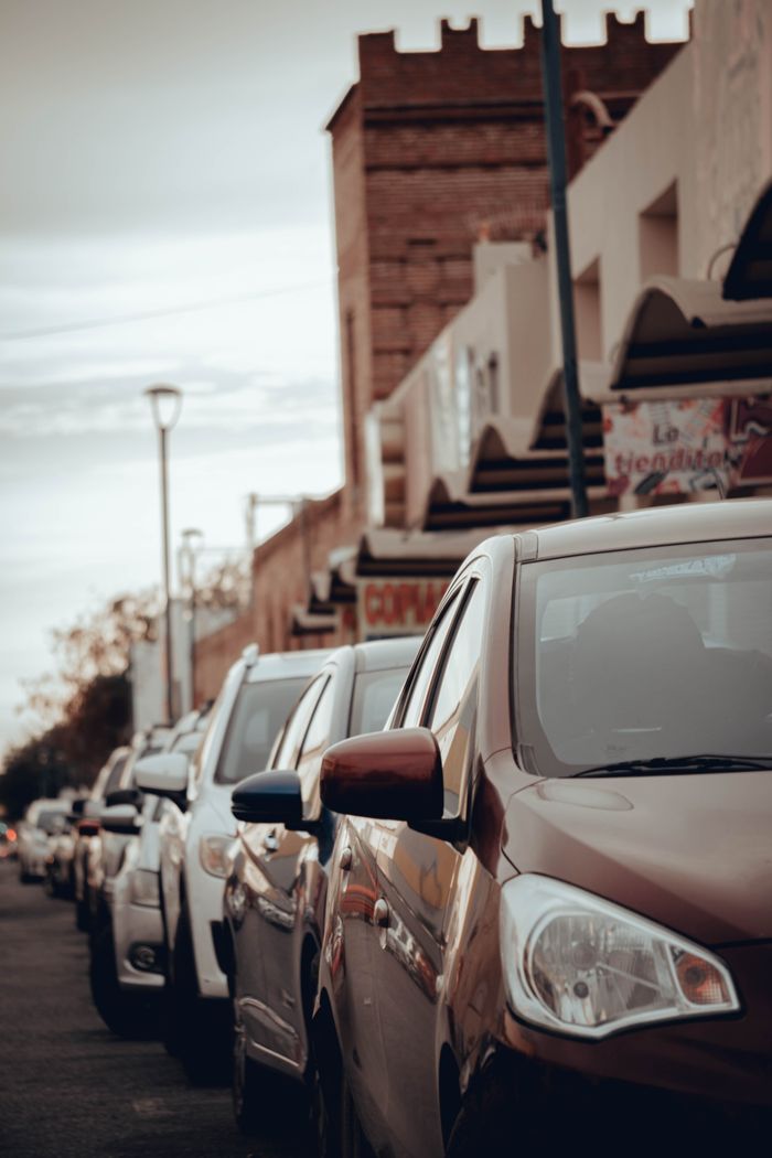 Mastering the First Impression: Your intriguing post title goes here City street featuring parked cars with urban buildings in the background, showcasing traffic and city life.